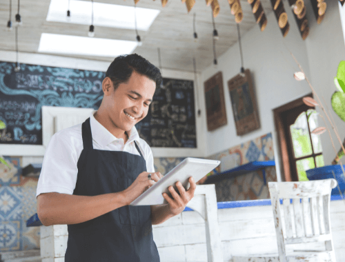 Woman with tablet stood in doorway of restaurant